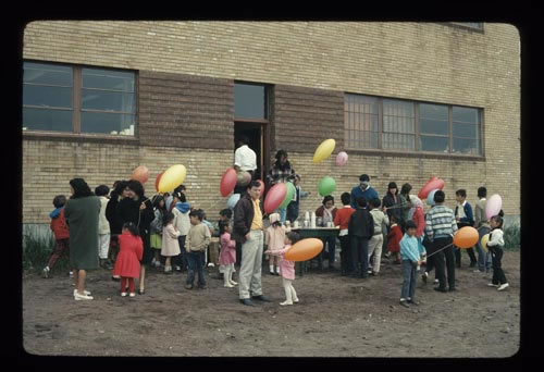 Photo of adults and children with balloons at 4th of July Celebration.