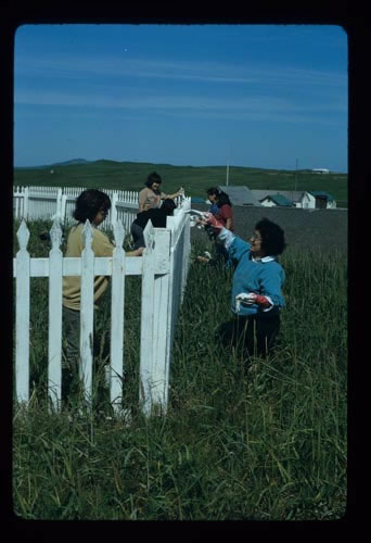 Photo of women painting the church fence.
