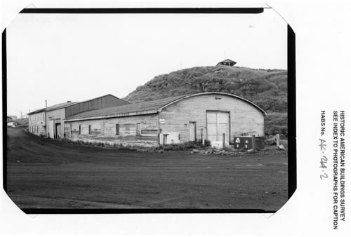 Photo of the equipment shed, a long building with a rounded roof.