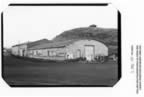 Thumbnail photo of the equipment shed, a long building with a rounded roof.