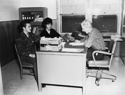 Photo of Nick Kozloff, Sr. and Lena Lekanoff seated in front of a desk.