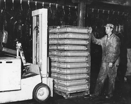 Photo of man with stacks of packaged sacks.