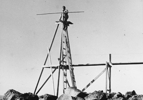 Photo of Patrick Kozloff Sr. on tripod used for counting northern fur seal populations.