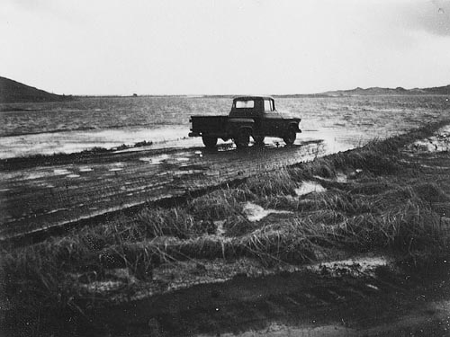 Photo of truck driving on water covered road.