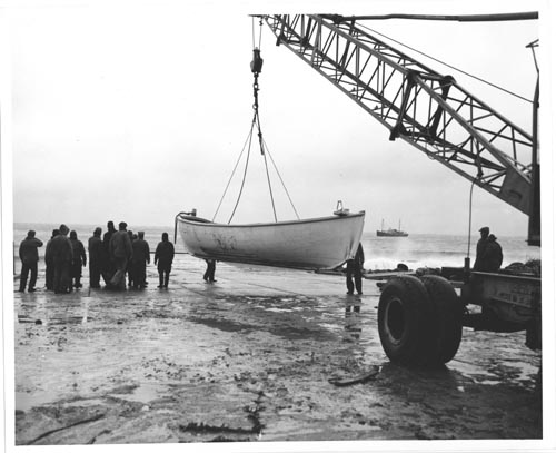 Photo of lifeboat being carried to dock.