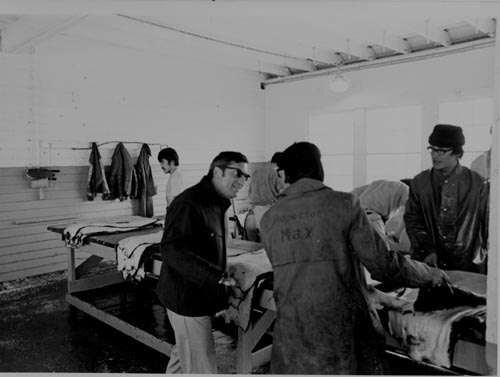 Photo of men inside processing plant.