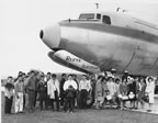 Thumbnail photo of young men and women standing in front of an airplane.