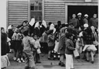 Thumbnail photo of Fouke Fur Company providing cookies and lemonade to a large group of mostly children outside of a building.