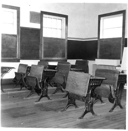 Photo of wooden school desks.