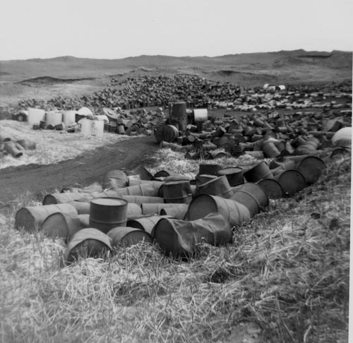 Photo of large piles of rusting drums.