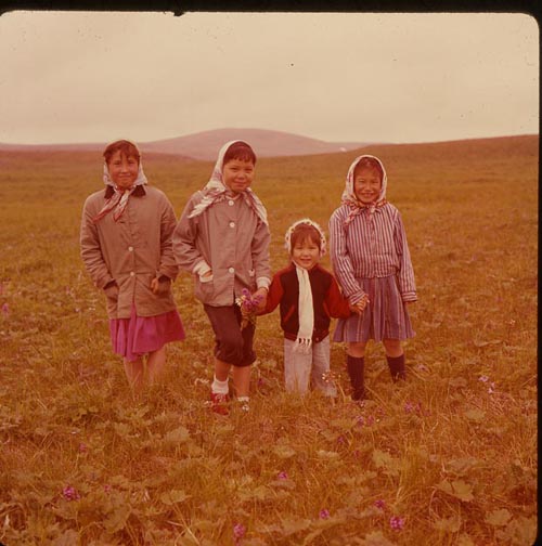 Photo of four girls, Linda, Janet, Joanne, and Betty Merculief, picking flowers.