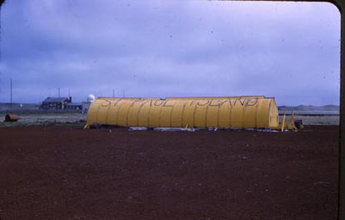 Photo of airport hangar and Nation Weather Service Station in the background.
