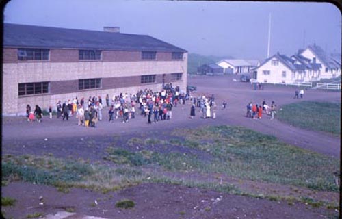 Photo of a large group of people outside of a building on the fourth of July.