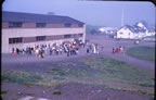 Thumbnail photo of a large group of people outside of a building on the fourth of July.