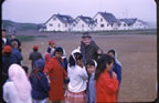 Thumbnail photo of children gathering around older man.