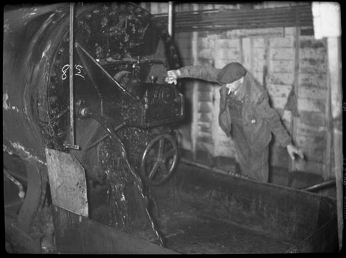 Photo of man operating machine inside the By-Products Plant.