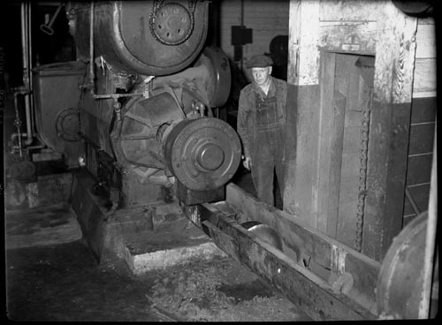 Photo of man next to machinery inside the By-Products Plant.