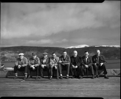 Photo of a group of men sitting in a row.