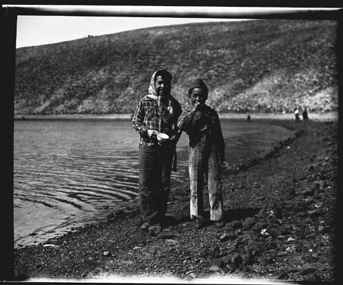 Photo of two children near body of water.