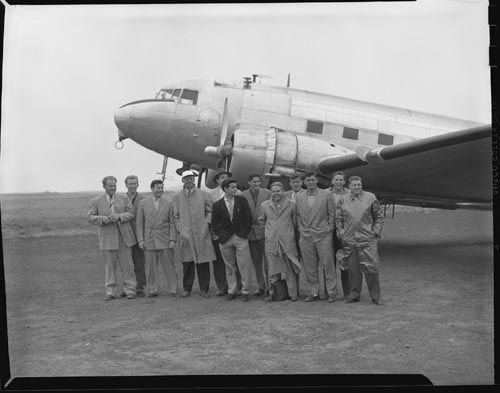 Photo of group of men near airplane.