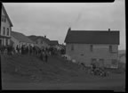 Thumbnail photo of a large group of people standing by buildings at a fourth of July celebration.