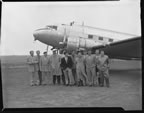 Thumbnail photo of group of men near airplane.