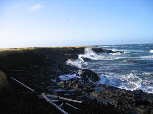 Photo of waves breaking on rocky coastline.