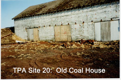 Photo of the Old Coal House, a heavily weathered white building.