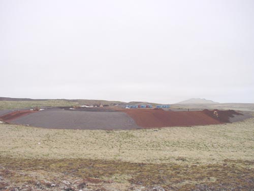 Photo of Active Landfill cap construction, a wide low dome of earth.