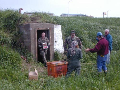 Photo of people removing explosives from the Explosives Storage Bunker.