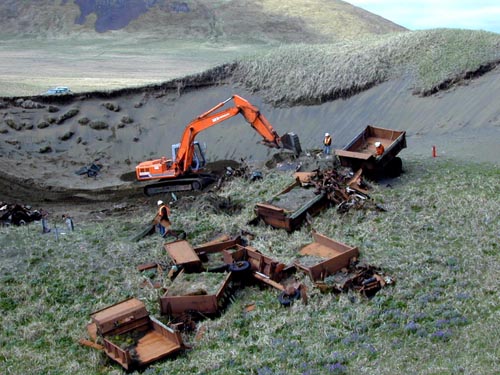 Photo of heavy equipment along grassy hillside with site remediation in progress at the Dune Vehicle Boneyard.