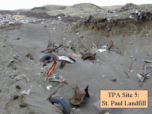 Photo of municipal solid waste in St. Paul Landfill Cell C, prior to remediation showing partially buried debris in sand and along hillside.