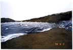 Thumbnail photo of a tarp covered area at the soil stockpile at Polovina Hill.