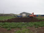 Thumbnail photo of site remediation in progress at the Tract 50 foundation showing showing heavy equipment near a patch of bare earth.