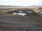 Thumbnail photo of soil sampling locations in the Tract 50 foundation excavation showing a large muddy hole with stakes.