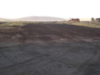 Thumbnail photo of a wide expanse of bare earth at the Tract 50 Foundation site, after environmental remediation.