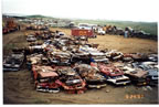 Thumbnail photo of vehicle Boneyard site prior to remediation showing stacks of crushed cars and other vehicles.