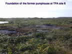 Thumbnail photo of the foundation of the former pumphouse in grassy area.
