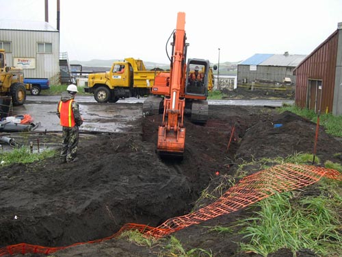 Photo of an excavator digging a ditch.