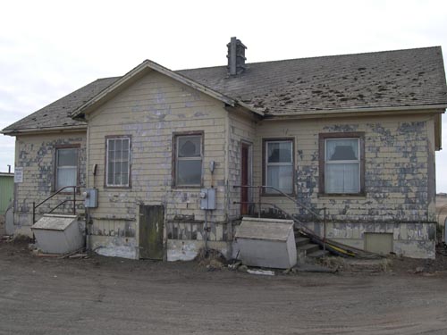 Photo of weathered yellow buildings.