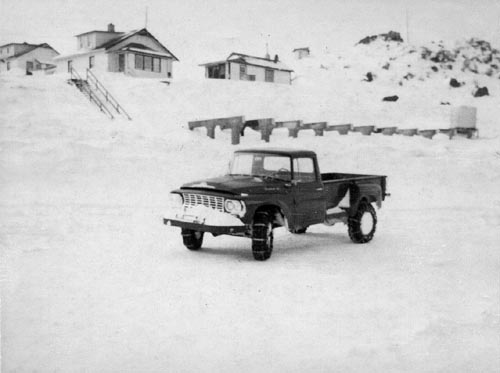 Photo of an old pickup truck on snowy landscape.