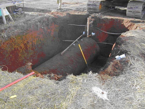 Photo of a cylinder in hole in the ground.