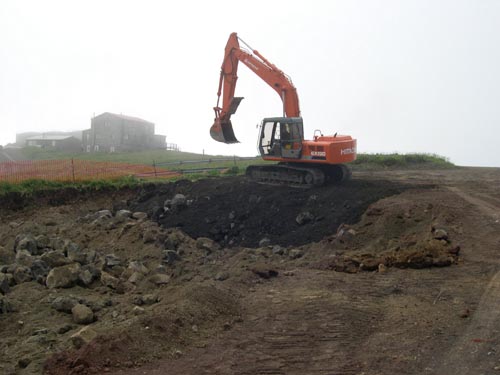 Photo of an excavator digging a hole.