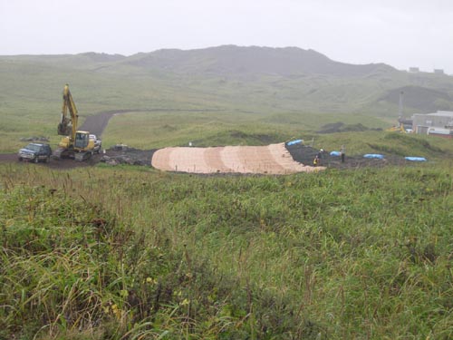 Photo of heavy equipment on green hillside.