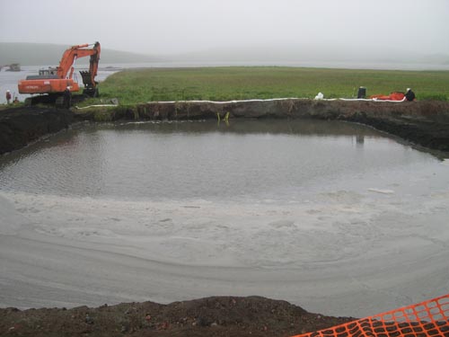 Photo of a large rectangular hole filled with water.