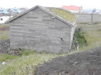 Thumbnail photo of a weathered gray building.