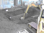 Thumbnail photo of an excavator digging a hole around a partially buried cylinder.
