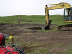 Thumbnail photo of an excavator digging hole in grassy area.