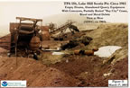 Thumbnail photo of empty drums, abandoned quarry equipment with conveyors, partially buried "Bay City" crane, and wood and metal debris at Lake Hill Scoria Pit.