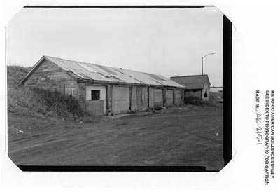 Photo of a six-car garage, a long wooden building.
